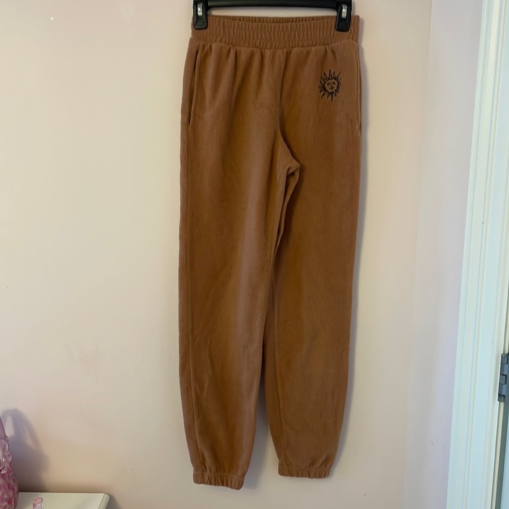 brownish/burnt orange sweatpants with sun in corner